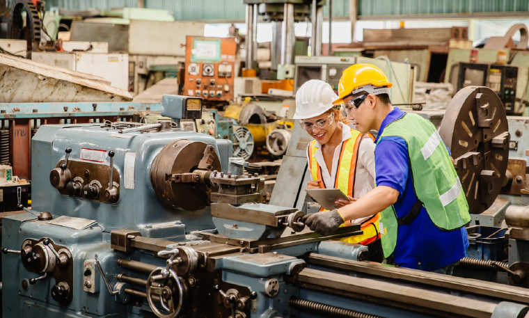 Workers wearing safety gear check the proper functioning of industrial equipment.