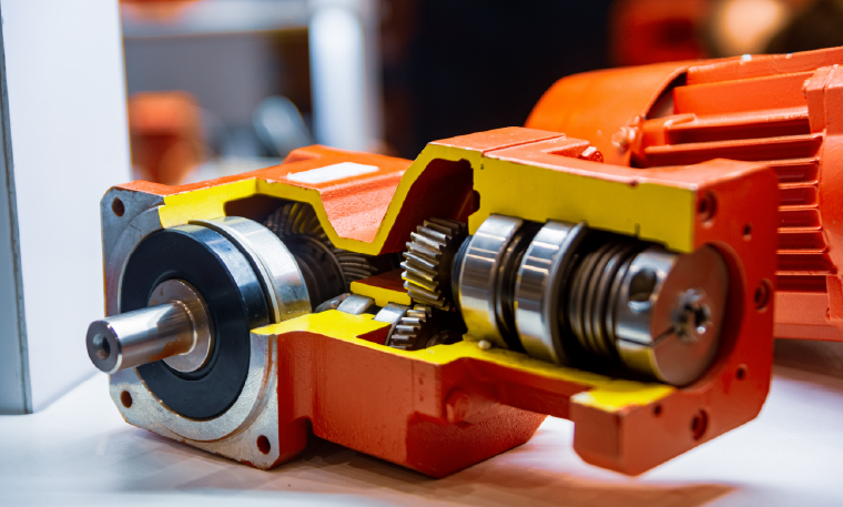 An industrial gearbox is painted orange and yellow based on OEM specifications after it is refurbished.