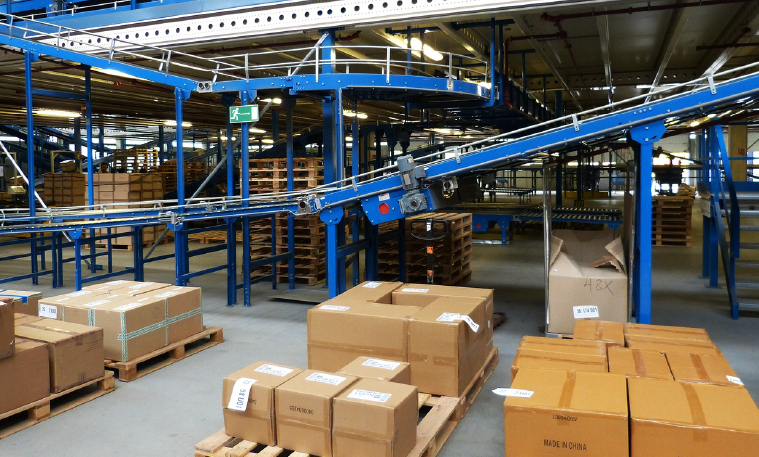 A warehouse with packed boxes and blue conveyor belts that use Falk shaft mount gearboxes.